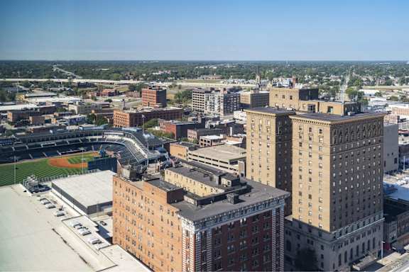 A cityscape with a baseball field in the foreground.