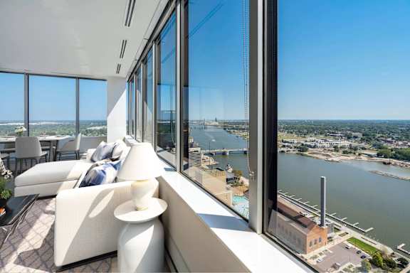 A modern living room with a view of the cityscape and water.