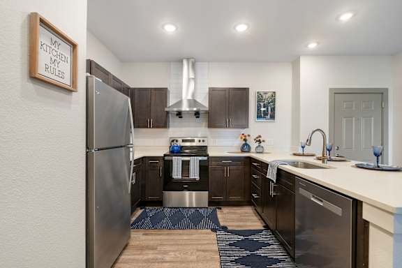 an open kitchen with stainless steel appliances and a refrigerator at 41 North Senior Living Apartments, Indiana