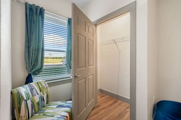 a bedroom with a window and a closet with a door at 41 North Senior Living Apartments, Fort Wayne, 46835
