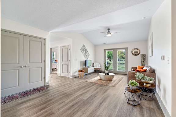a living room with white walls and a ceiling fan at Morada at Maysville Apartments, Fort Wayne, Indiana