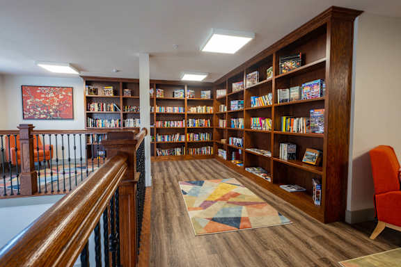 a library with wooden shelves and a staircase at Ritchey Reserve Apartments, Indiana 46038