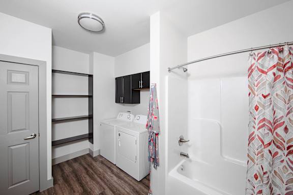 A white bathroom with a shower curtain and a white cabinet at Ritchey Reserve Apartments, Fishers