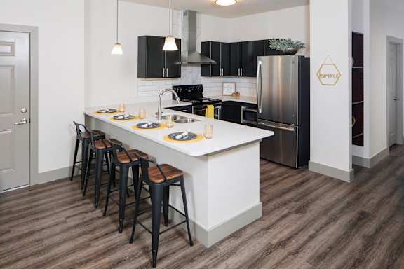 a kitchen with a large island and black appliances at Ritchey Reserve Apartments, Fishers, IN, 46038