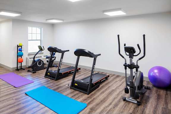 a gym with exercise equipment and yoga mats at Ritchey Reserve Apartments, Fishers, Indiana