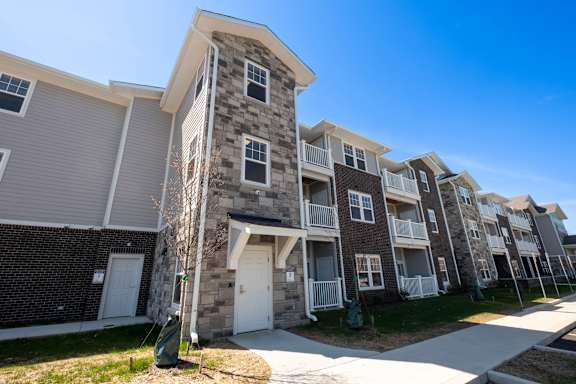 an apartment building with a stone exterior and white doors at Ritchey Reserve Apartments, Indiana