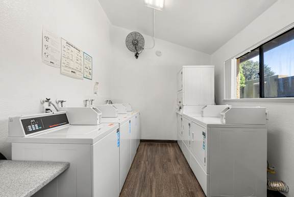 A clean, white-walled medical or laboratory room with a bench and a couple of cabinets.