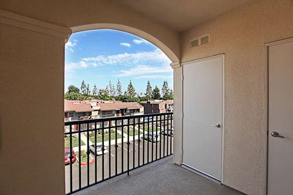 A balcony with a black railing and a view of a residential area.