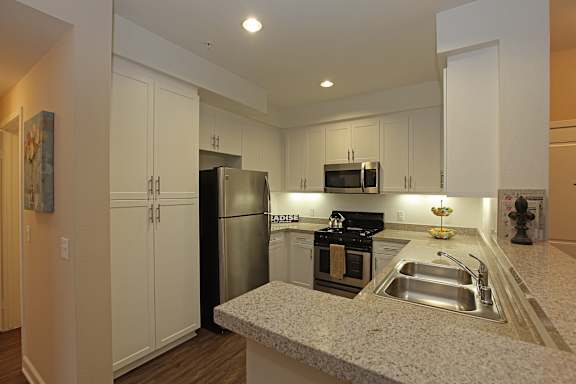 A kitchen with a granite counter top and stainless steel appliances.