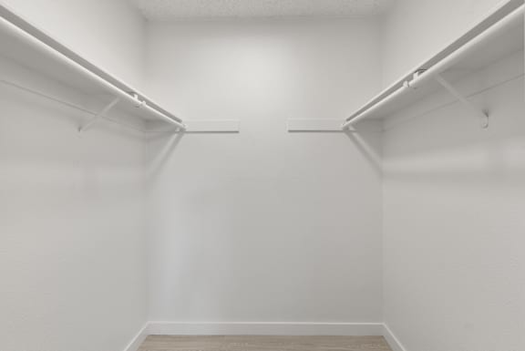 A white room with two shelves on the wall.