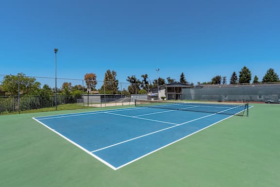 A tennis court with a blue surface and white lines.