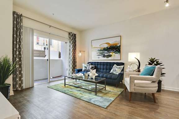 A living room with a blue couch and a painting on the wall.at Vues on Gordon, Los Angeles California