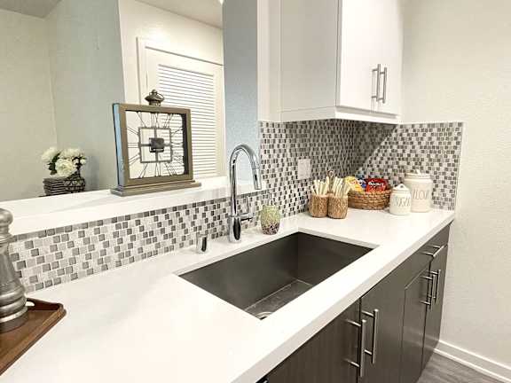 A kitchen with a black and white checkered backsplash.at Vues on Gordon, California