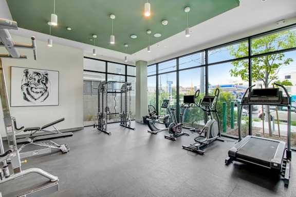 a workout room with gym equipment and large windows