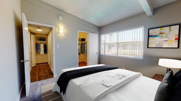 a bedroom with a bed and a door to a walk in closet