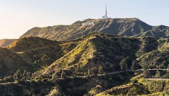 A hill with a cell tower on top and a sign that says "HOLLYWOOD" on it.
