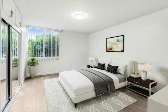 a white bedroom with a bed and a sliding glass door