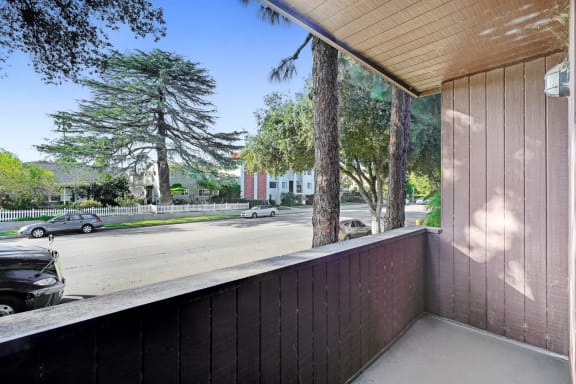 a balcony with a view of a street and trees