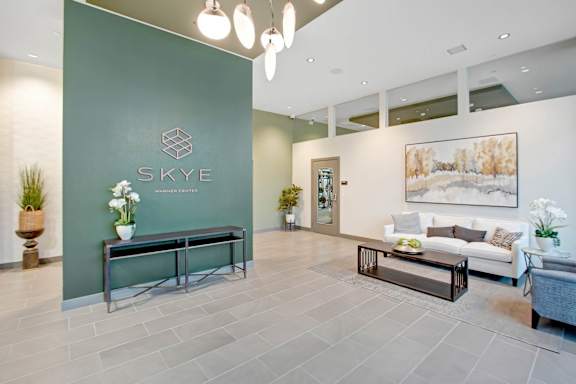 a lobby with a green wall and a couch and a table