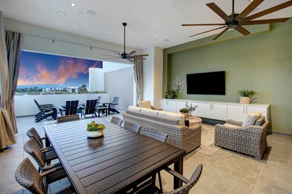 a large living room with a wooden table and chairs