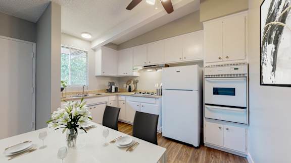 a white kitchen with white appliances and a white table
