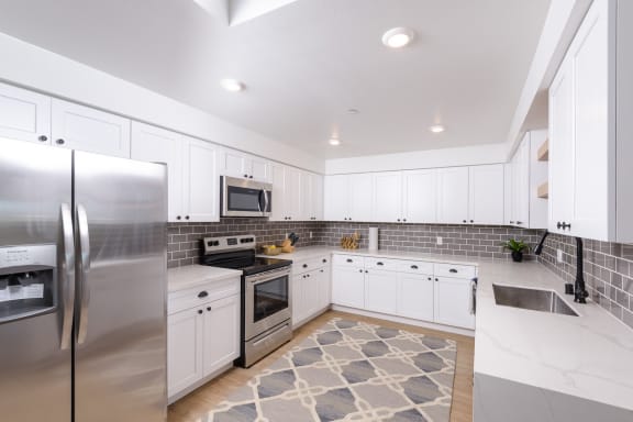 a kitchen with stainless steel appliances and white cabinets
