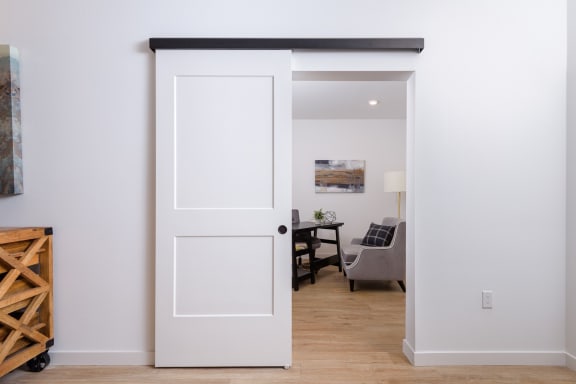 a white sliding door is open to a living room