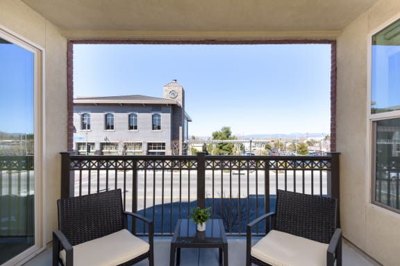 a balcony with two chairs and a view of a building