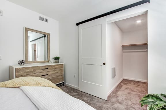 a bedroom with a bed and a dresser with a mirror