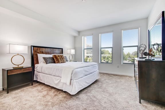 a bedroom with a bed and three windows