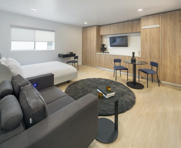 a living room with a couch and a table and a bed