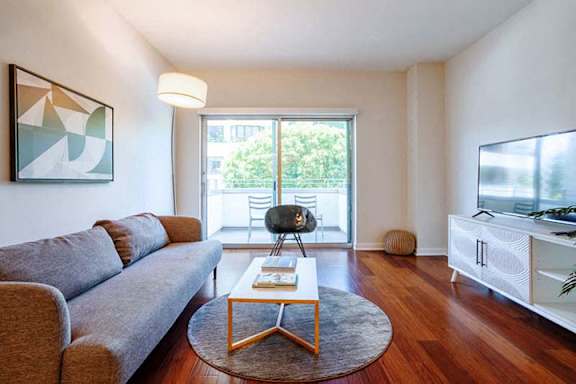 a living room with a couch and a table and a television a living room with a couch and a table and a television at Wilshire Margot, Los Angeles