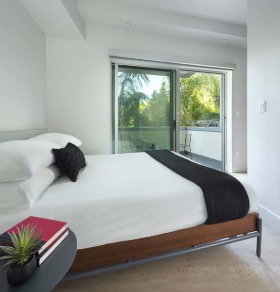 a bedroom with a bed and a sliding glass door