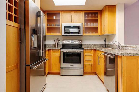 a kitchen with stainless steel appliances and wooden cabinets a kitchen with stainless steel appliances and wooden cabinets at Wilshire Margot, Los Angeles California