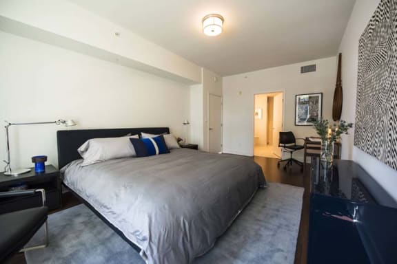 a bedroom with a large bed and a desk