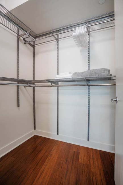 a large closet with metal shelving and a wooden floor