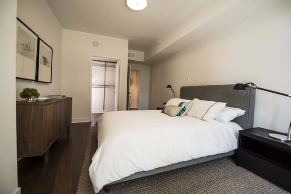 a bedroom with a large white bed and a dresser