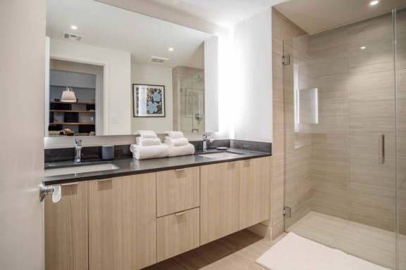 a large bathroom with two sinks and a shower