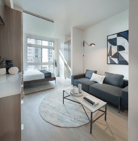 a living room with a couch and a coffee table and a bedroom with a bed a living room with a couch and a coffee table and a bedroom with a bed at Wilshire Margot, Los Angeles, 90024