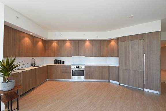 a large kitchen with wooden cabinets and a wooden floor a large kitchen with wooden cabinets and a wooden floor at Wilshire Margot, Los Angeles, CA 90024