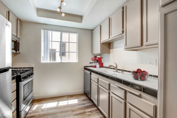 a kitchen with white cabinets and a window
