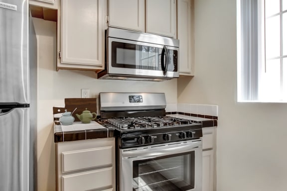 a kitchen with white cabinets and stainless steel appliances
