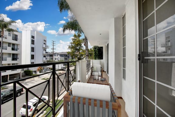 a balcony with a white couch and two chairs