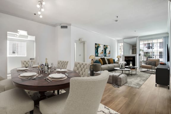 a dining room and living room area with white walls and hardwood floors