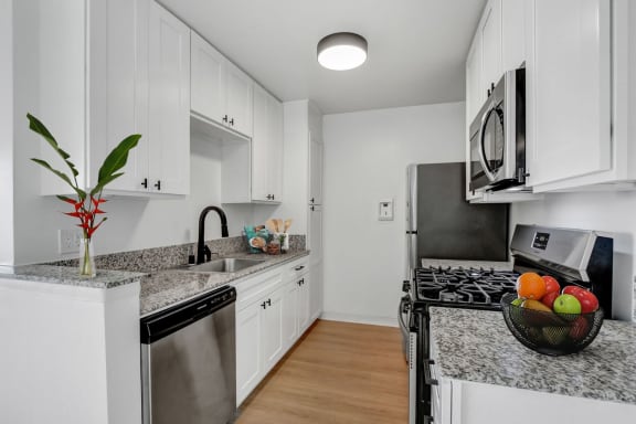 a kitchen with white cabinetry and granite countertops