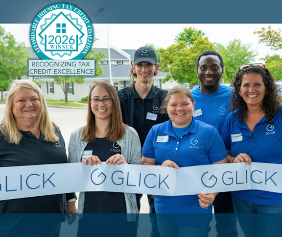 A group of people holding a banner that says "GLICK" in front of a logo for the 2026 Tax Credit Excellence Award.