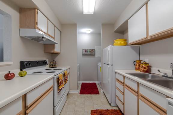 A kitchen with white cabinets and a refrigerator.