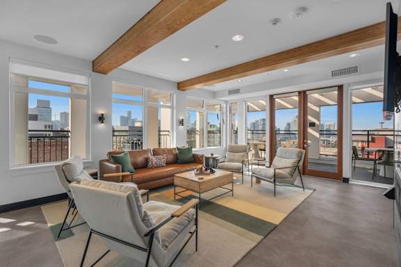 A living room with a brown couch and a white chair.