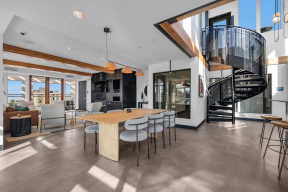 A modern open-plan living space with a spiral staircase.