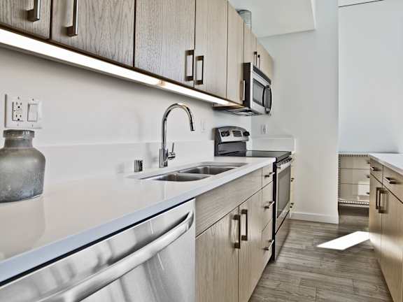 A modern kitchen with wooden cabinets and stainless steel appliances.
